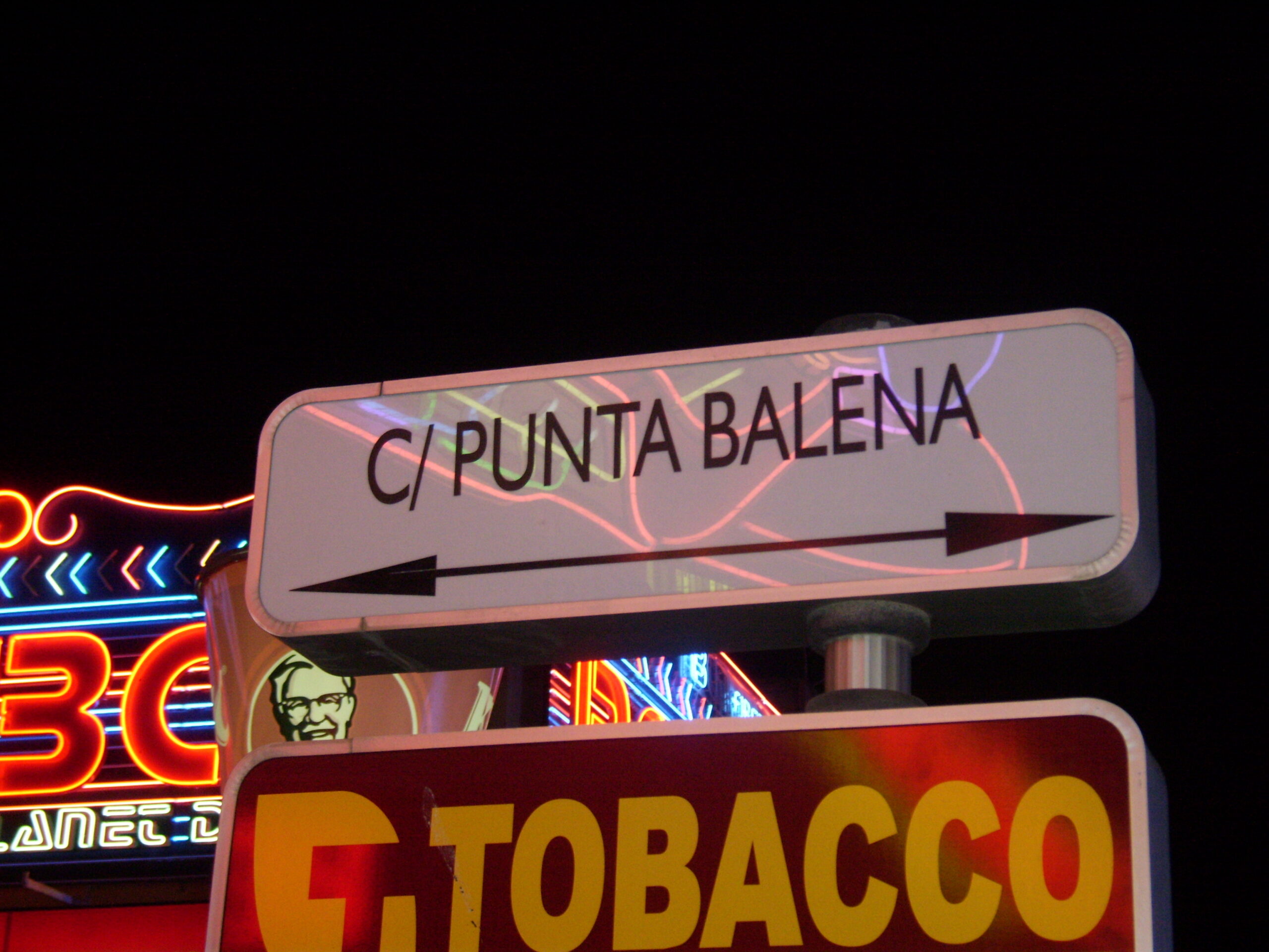 Het straatnaambord van de Punta Ballena tussen de neonreclames, de straat waar het nachtleven van Magaluf zich concentreert