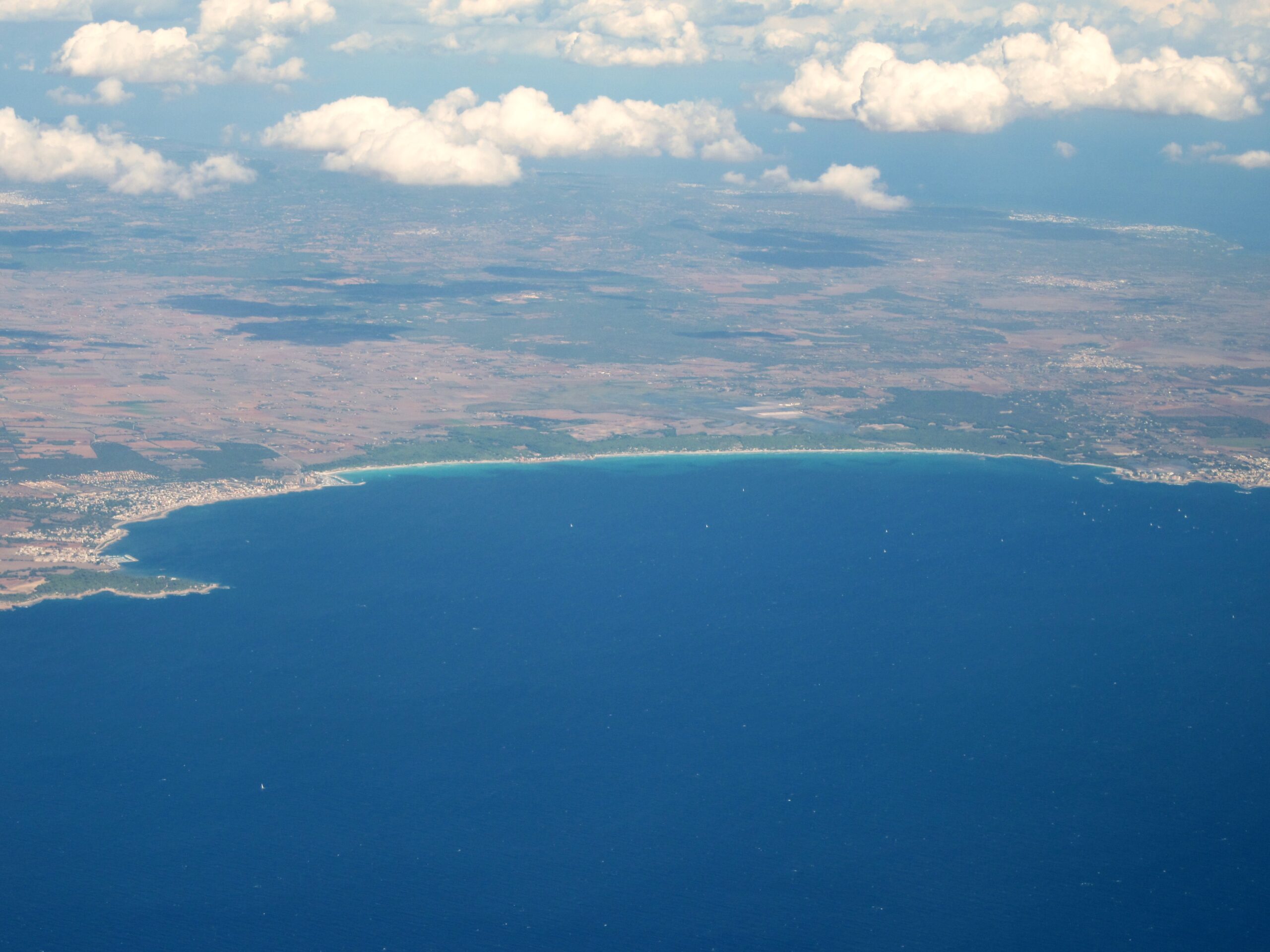 Luchtfoto van de zuidkust van Mallorca waarop de lange onbebouwde zandstrook van Es Trenc ligt tussen de vlakte van Campos en de zee