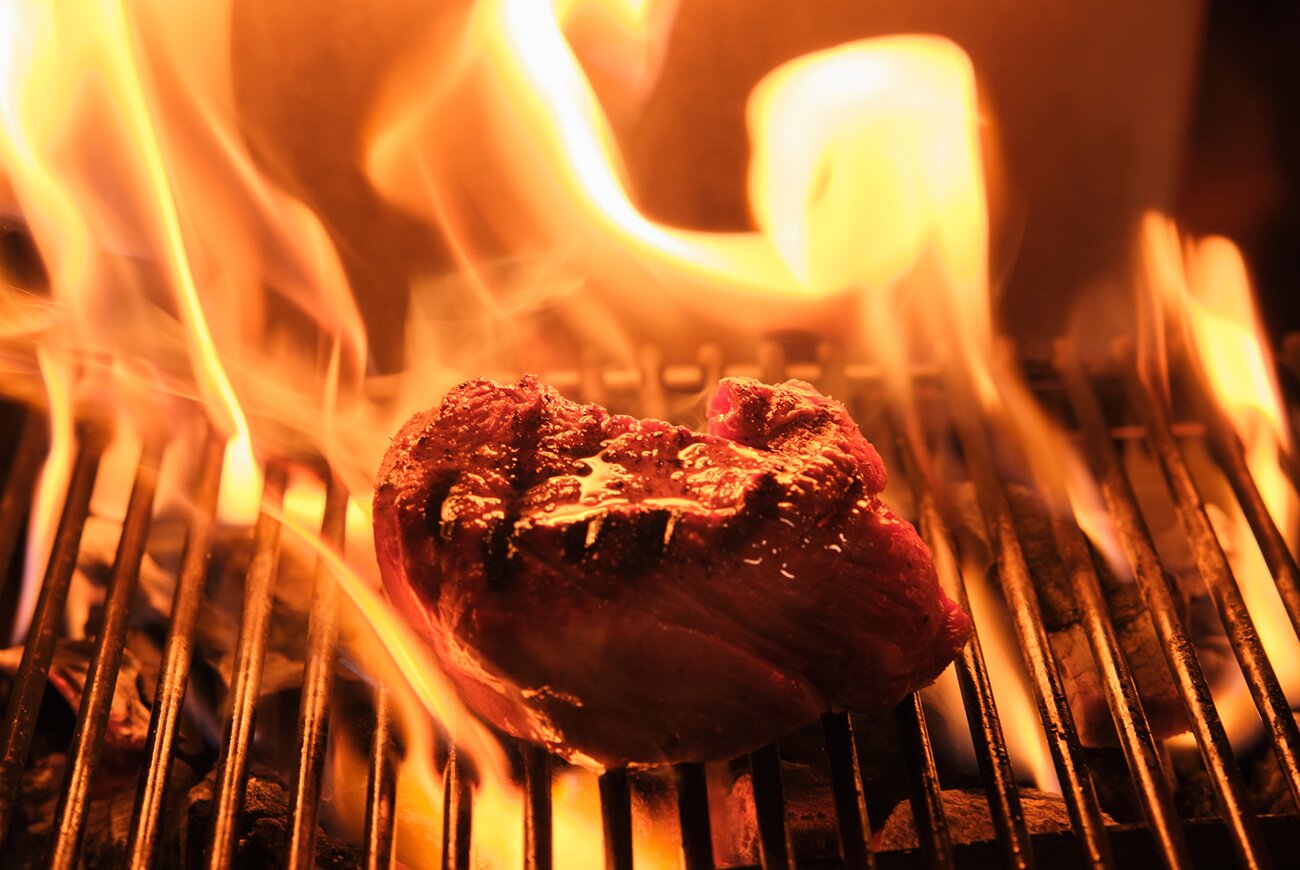 Quadrat in Palma: eten in de tuin van Hotel Sant Francesc 6 Een stuk vlees boven de open vlammen van de grill in de keuken van Quadrat in Palma