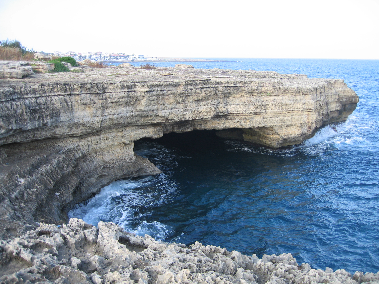 Door de zee uitgeholde grot onder de kalkstenen kustplaat bij Sant Lluís op Menorca