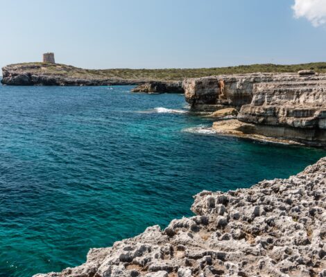 S'Algar Menorca: geen zand, zwemmen vanaf de rotsen 2 Vlakke kalkstenen rotsplaten en helder turquoise water aan de kust bij S'Algar in de zuidoosthoek van Menorca