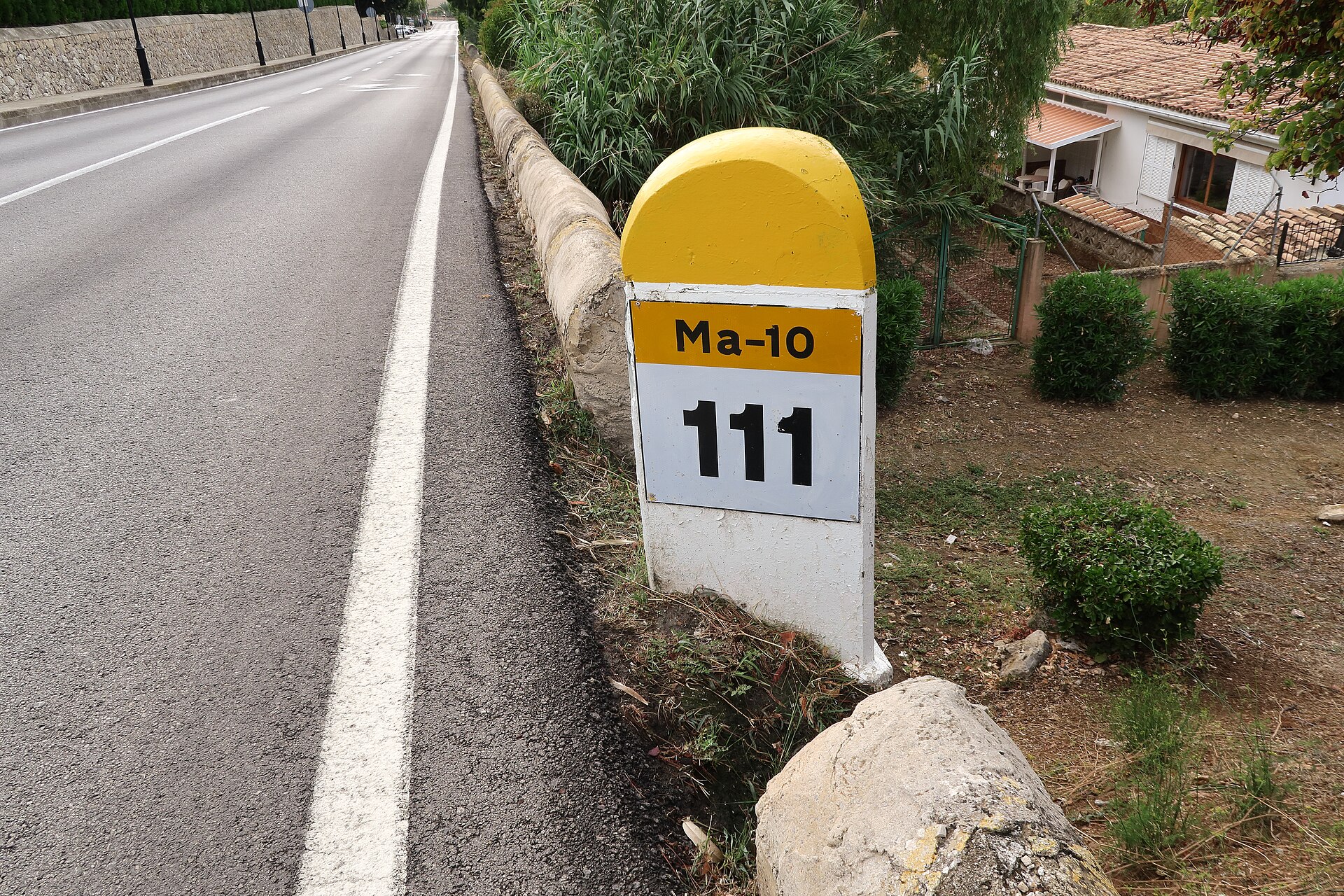 Gele kilometerpaal langs de weg met het opschrift Ma-10 en het getal 111, bij Andratx op Mallorca