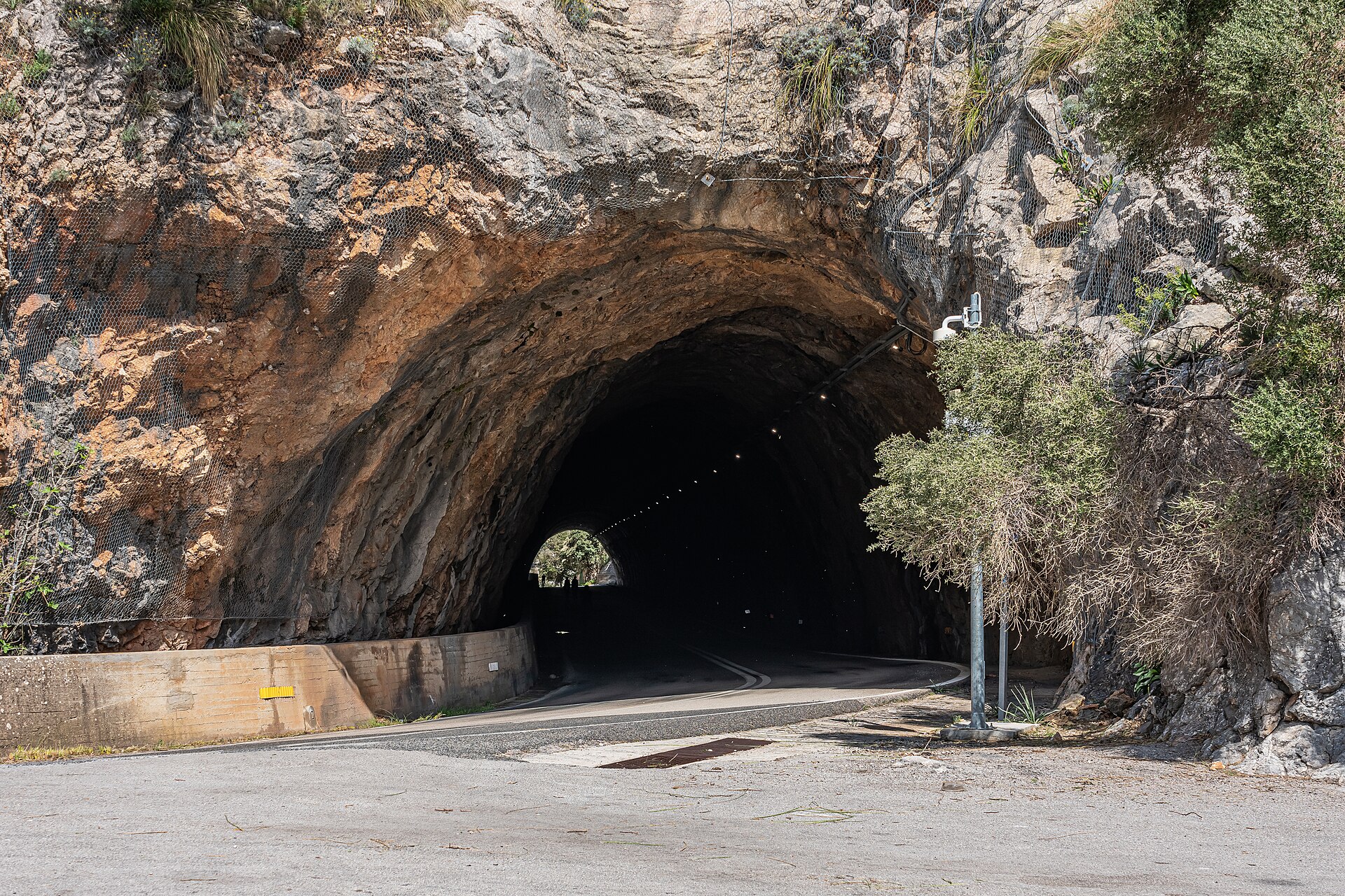 Tunnelmond in een ruwe rotswand langs de Ma-10 bij het stuwmeer Gorg Blau in de Serra de Tramuntana
