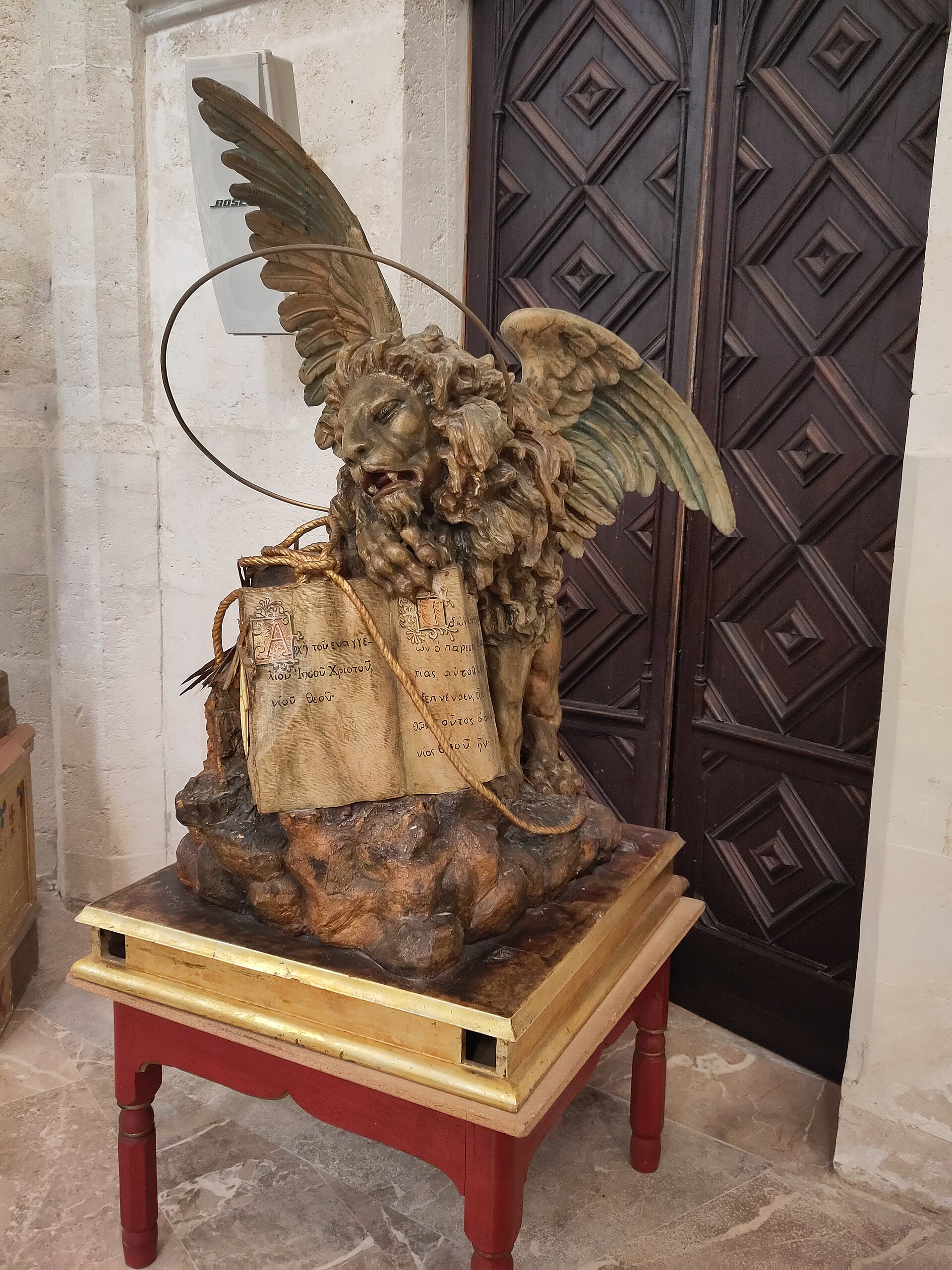 Houten beeld van de gevleugelde leeuw van Sint Marcus in de kerk van Sineu, met het opengeslagen evangelie tussen zijn klauwen