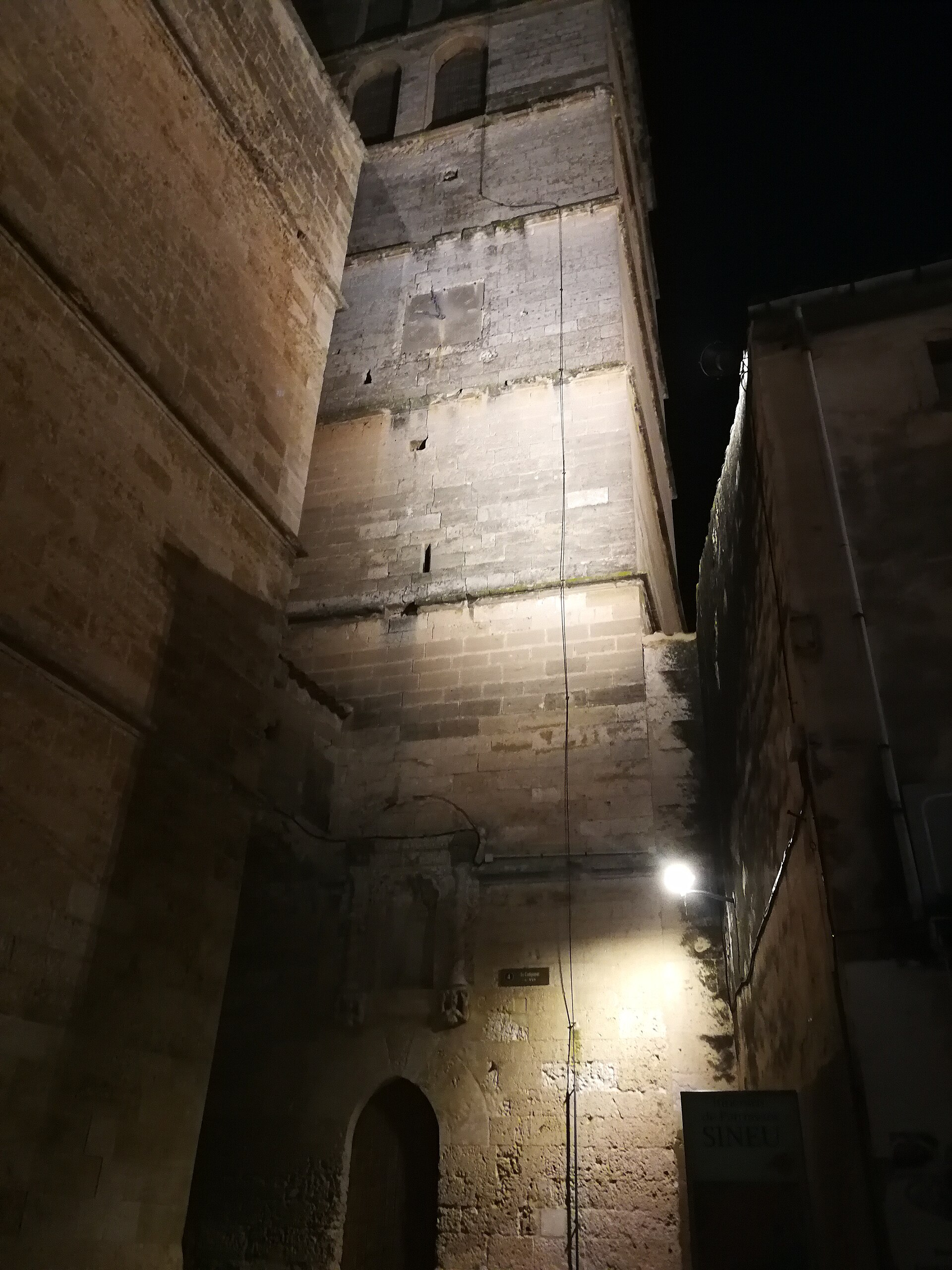 De verlichte klokkentoren van Santa Maria de Sineu tegen een donkere avondlucht