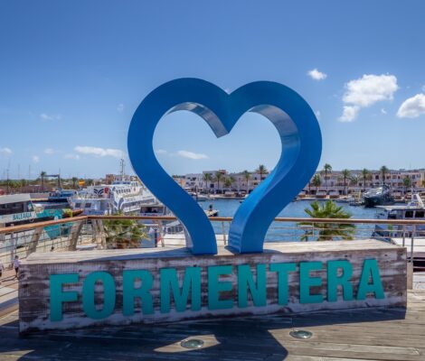 De haven van La Savina op Formentera met veerboten, jachten en het blauwe letterbord van het eiland