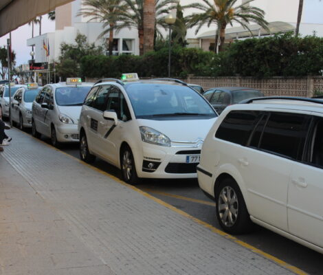 Rij witte taxi's met een taxibordje op het dak bij de standplaats in Cala Millor op Mallorca