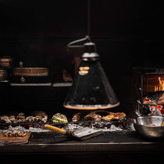 De houtskoolgrill van restaurant Terrae in Port de Pollença met groente en vis boven de gloeiende kolen