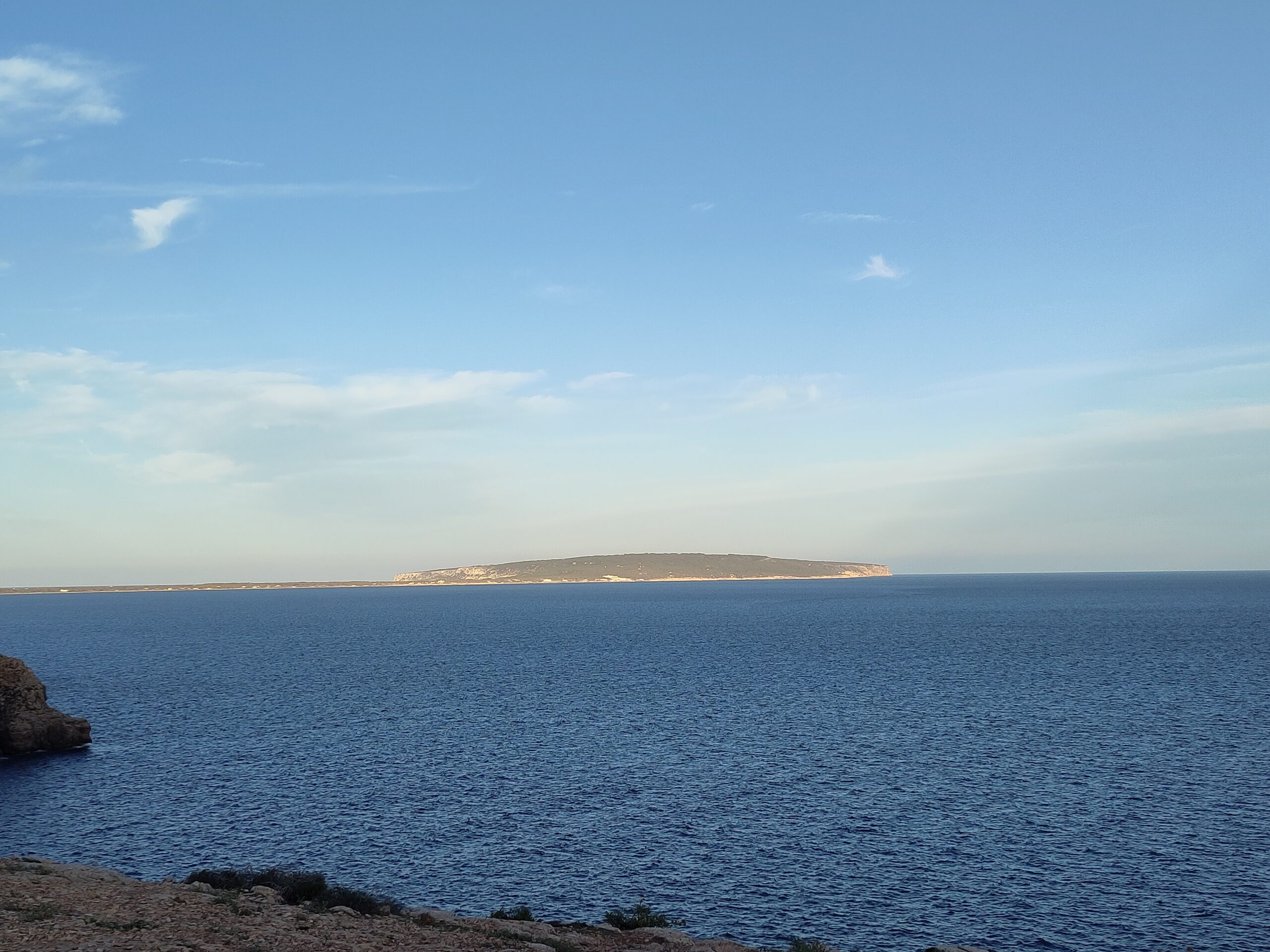 De kliffen van Cap de Barbaria op Formentera, met de hoogvlakte van La Mola aan de horizon